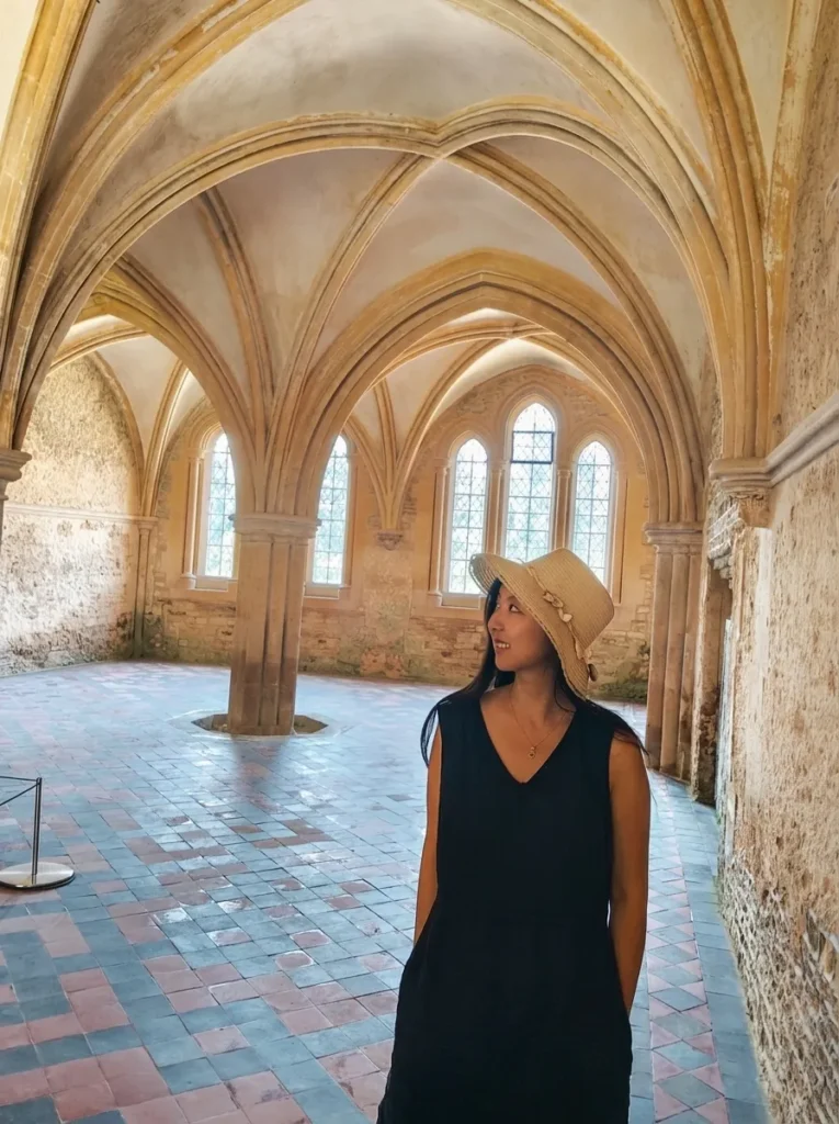 travel blog author Sophie Chen standing in the chapter house of lacock abbey, used as the filming location of the mirror of erised hall in harry potter