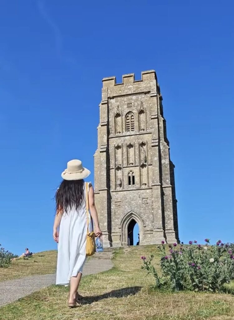 travel writer Sophie walking up the slope of Glastonbury Tor to see the roofless temple at the top