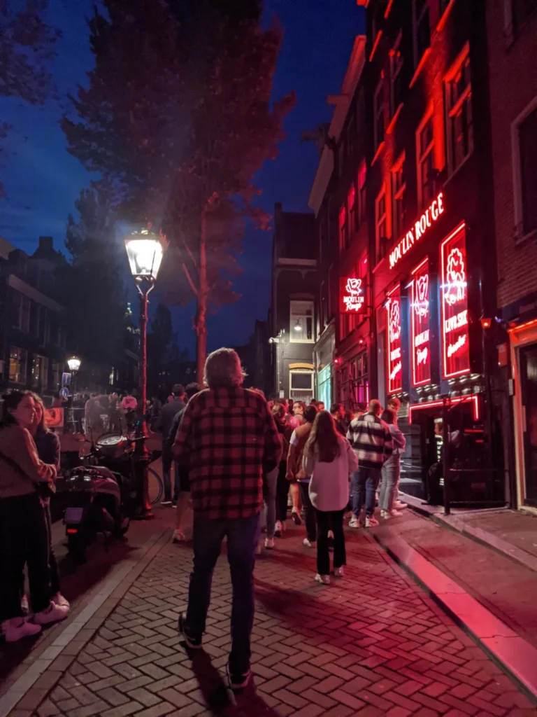 crowd in front of moulin rouge in amsterdam's red light district